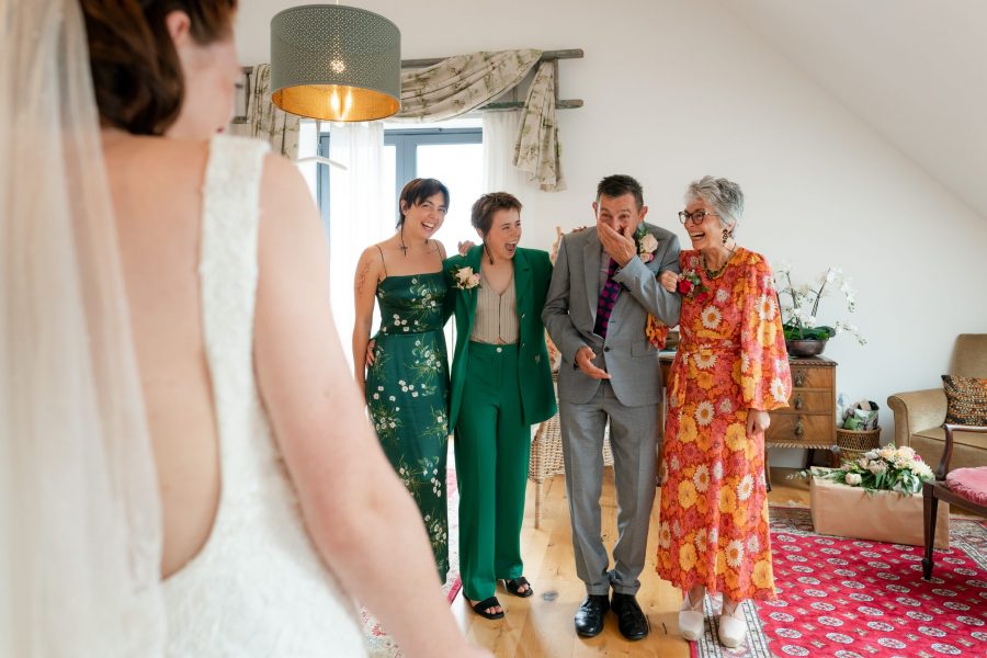 Brides father and family seeing her dressed in her gown for the first time.