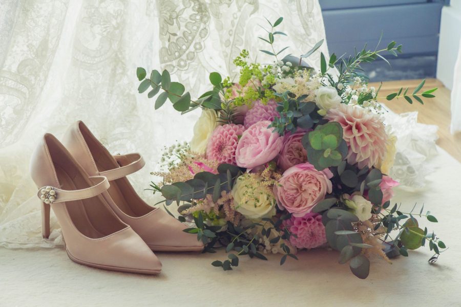 Detail of bridal bouquet and shoes on bride's veil