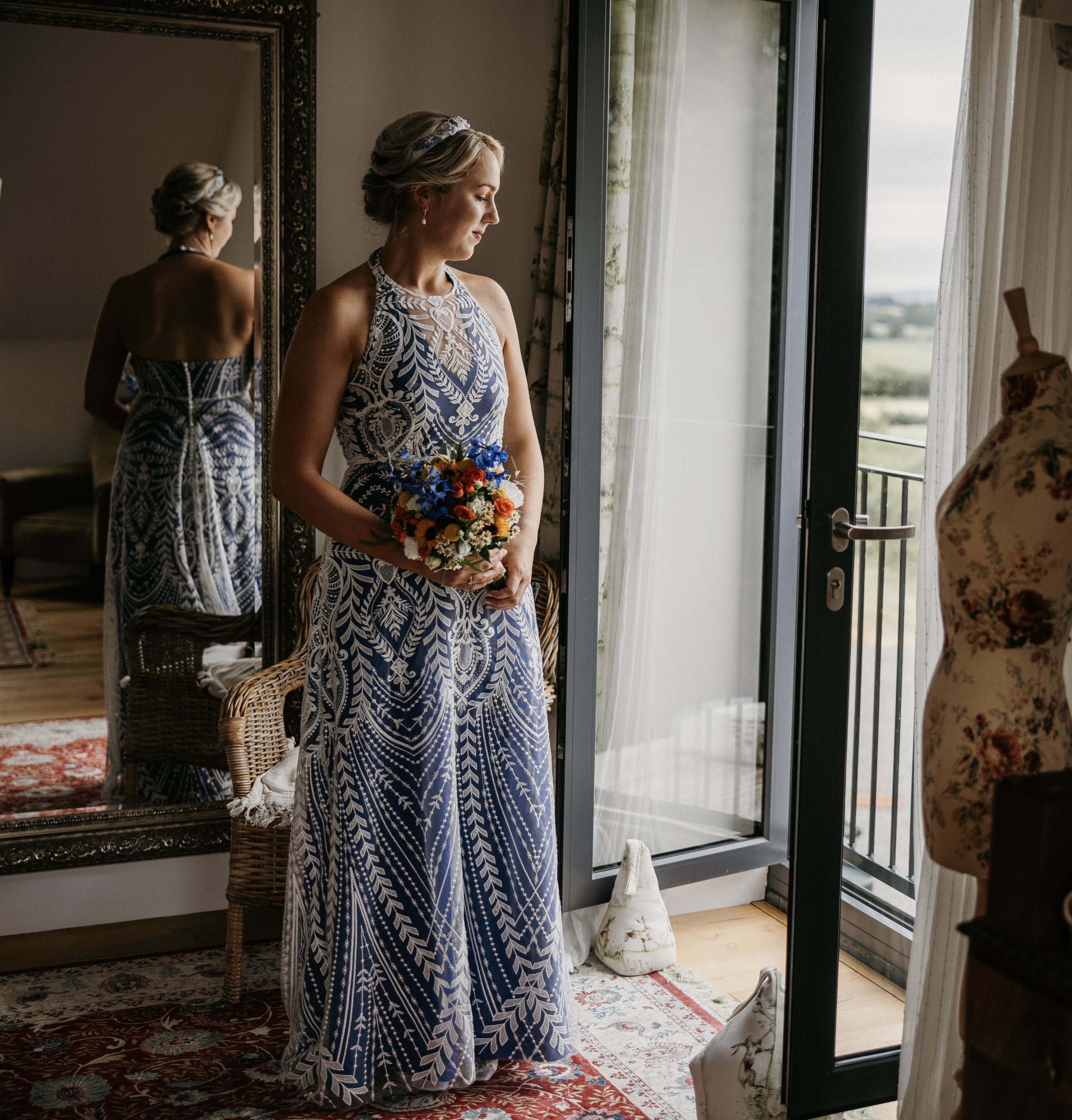 Bridal portrait of a bride in a beautiful bespoke lace dress with royal blue silk underlay.