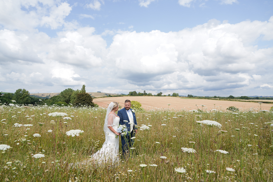 Shows couple walking in meadow with views behind