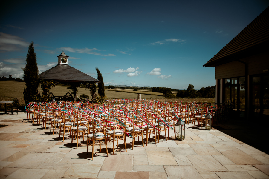 Ceremony set up on the terrace at Harefield Barn with be-ribboned chairs