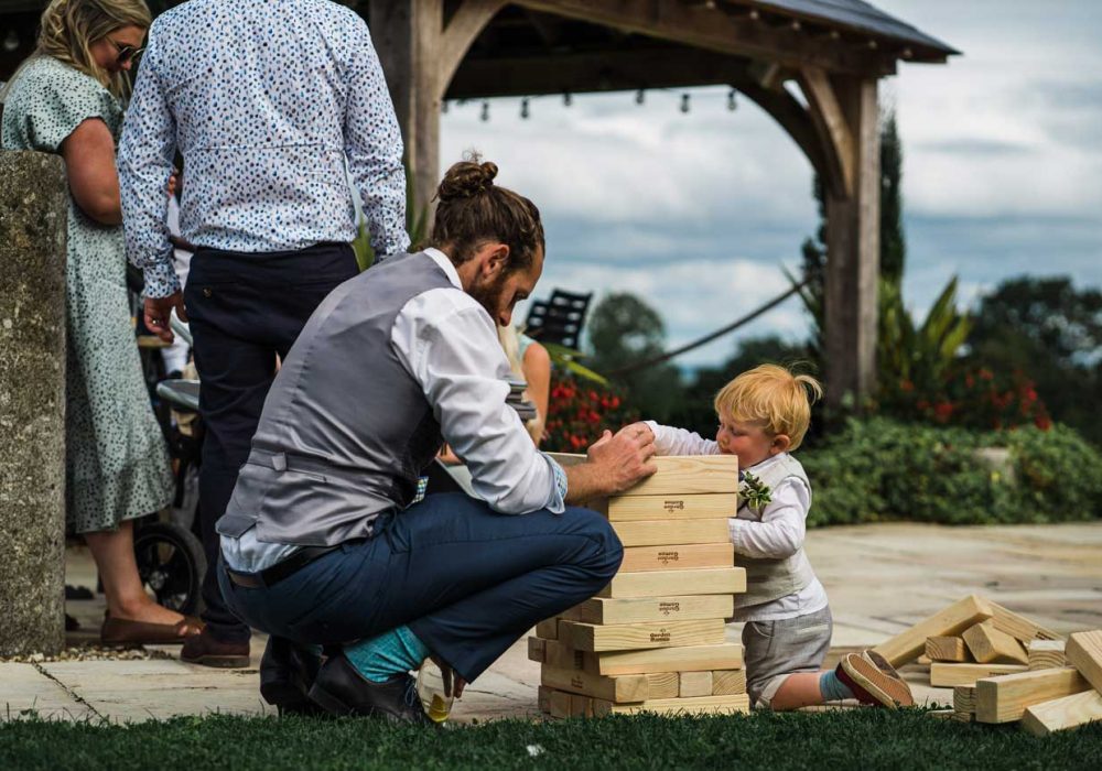 Playing Jenga with a small child at Harefield Barn wedding venue Devon