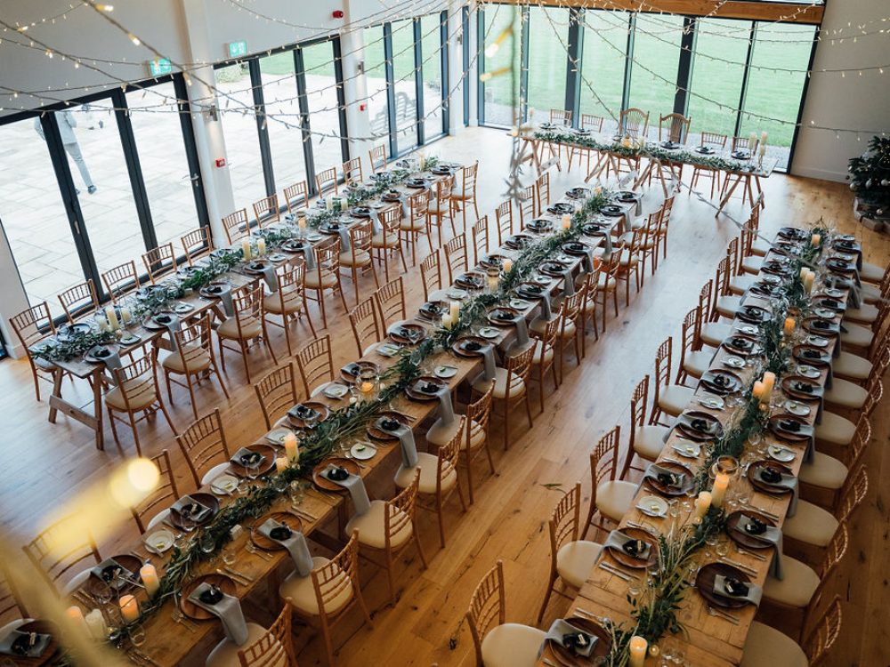 Tables set for evening reception at Harefield Barn wedding venue Devon